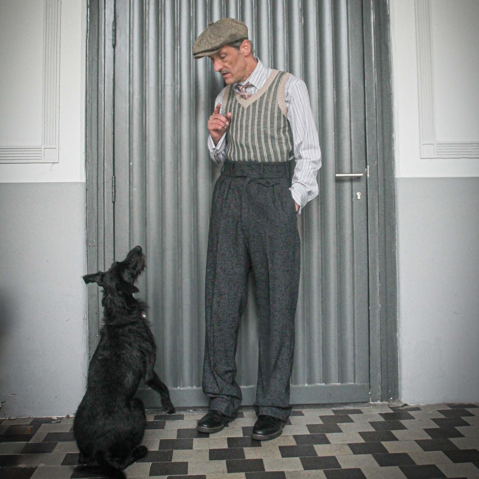 These high-waisted, pleated vintage-style trousers are made of rugged pure wool in a dark grey charcoal colour with small bright blue flecks.  The design is based on an original pattern from the 1940s with all the attention to details. They have 6 belt hoops for wearing with a belt. There are two generous side pockets, and a small change pocket at the front, as well as two back pockets. The buttons are made from coconut.