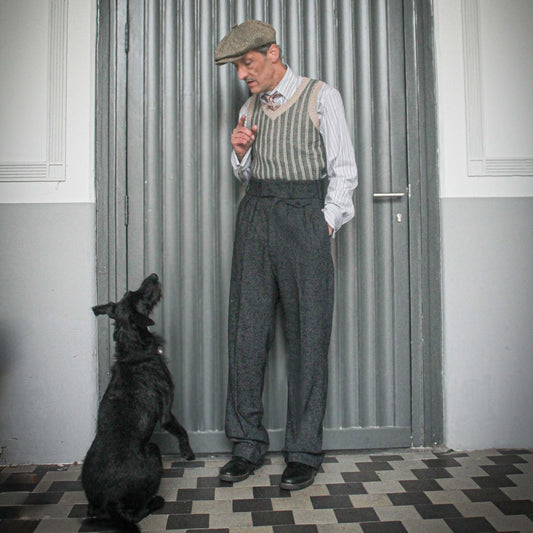These high-waisted, pleated vintage-style trousers are made of rugged pure wool in a dark grey charcoal colour with small bright blue flecks.  The design is based on an original pattern from the 1940s with all the attention to details. They have 6 belt hoops for wearing with a belt. There are two generous side pockets, and a small change pocket at the front, as well as two back pockets. The buttons are made from coconut.
